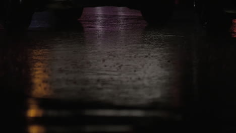 Close-up-view-of-rain-road-with-riding-car