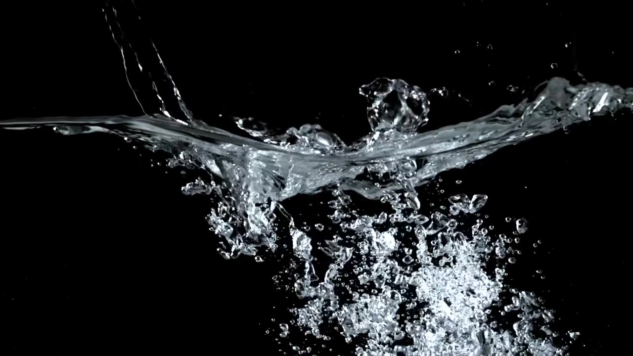 Acqua che si versa e schizza con bolle al rallentatore su sfondo nero