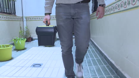 man carrying toolbox in interior building