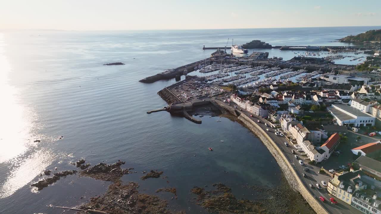 Flyvning over St Peter Port Guernsey langs Les Banques til Salerie Corner med udsigt over hele havnen, færge der sejler ind, Castle Cornet og til St Martins på en klar, rolig dag ved solnedgang