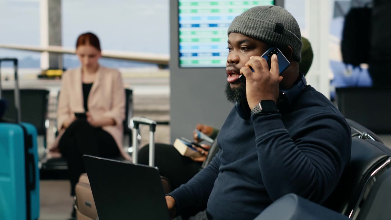 Black man in crisis mode talking on phone call to solve startup mistake