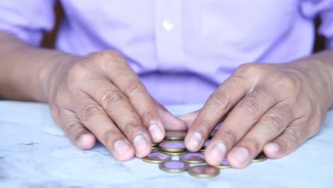 hombres jóvenes contando monedas a mano