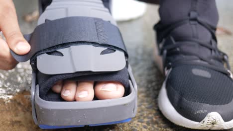 Frauen-Gebrochene-Füße-Mit-Einem-Grauen-Plastikstiefel-Knöchelbandage-Verletzungsschutzstiefel,