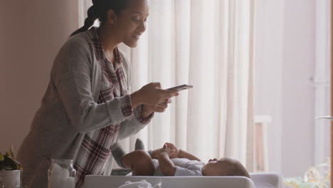 happy mother taking photo of baby using smartphone enjoying photographing cute toddler sharing motherhood lifestyle on social media