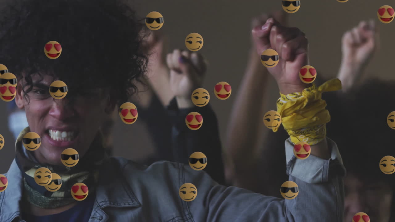 Woman and group raising fists indoors, with floating emoji icons highlighting technology theme