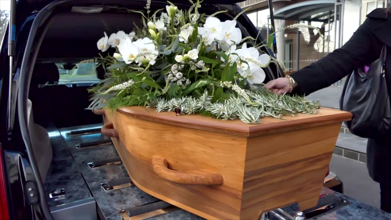 captura de pantalla de un ataúd funerario en un coche fúnebre o capilla o entierro en el cementerio