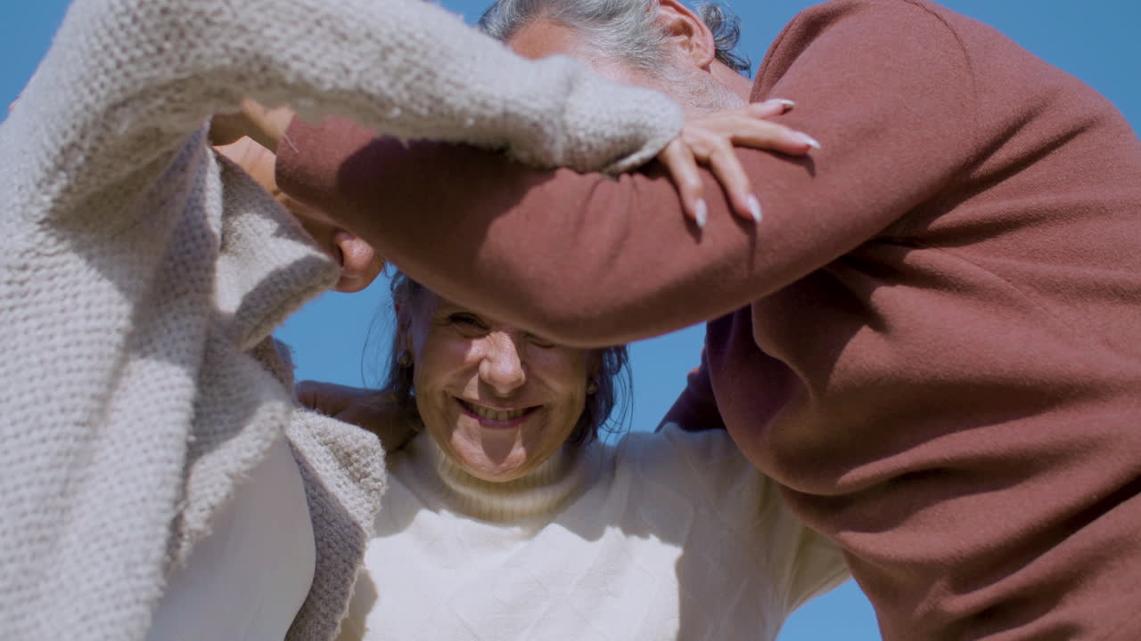 personas mayores felices de pie en círculo y abrazándose