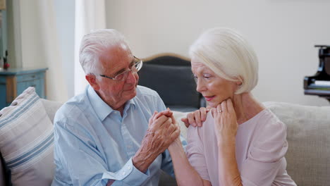 senior man comforting woman with depression at home