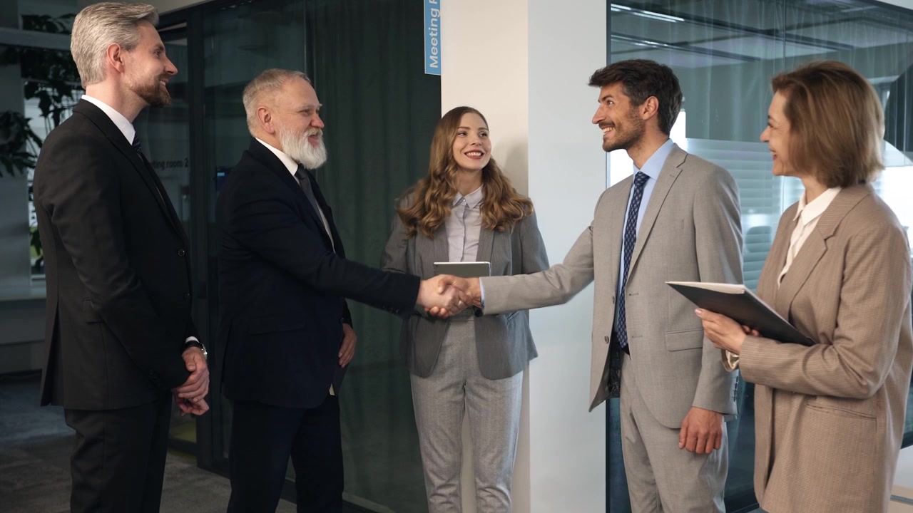Professionisti d'affari che si stringono la mano e parlano in un ufficio moderno