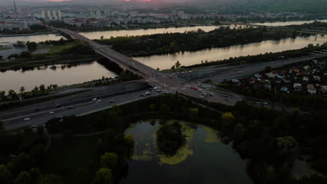 Dusk-glow-spread-across-Vienna-city-skyline-and-highway-exchange-ramp-by-Donauinsel-island