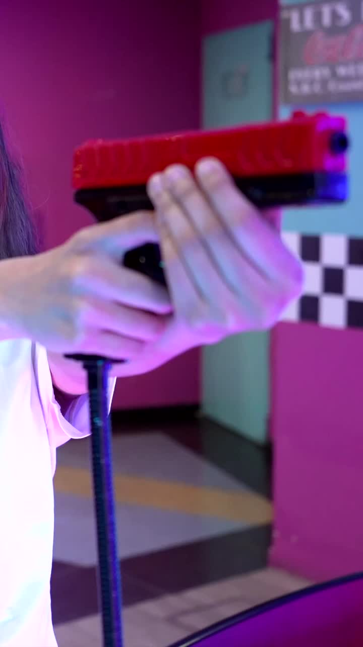 Woman playing a shooting game at an arcade