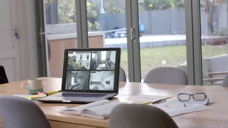 laptop on dining table showing four home security camera views, slow motion