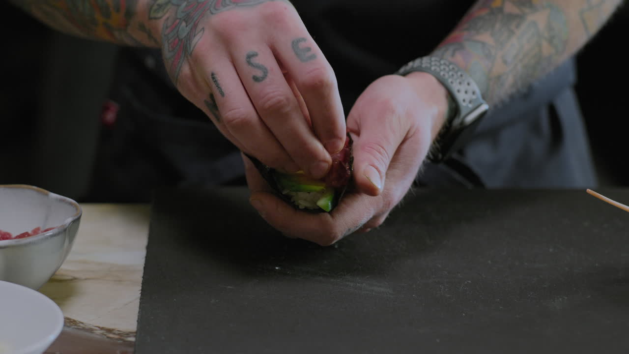 Closeup shot of a chef preparing sushi hand rolls