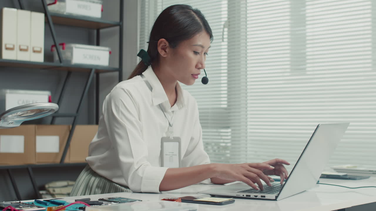 Female Repair Center Manager Consulting Clients via Headset and Laptop