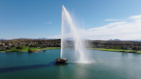 drone rises along large grand fountain of water in green community of arizona