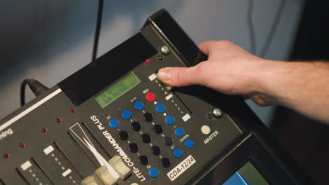 close-up shot of hand adjusting dial on professional video equipment. setting controls on multimedia device, focusing on buttons with led display in studio lighting, cinematic effect in action