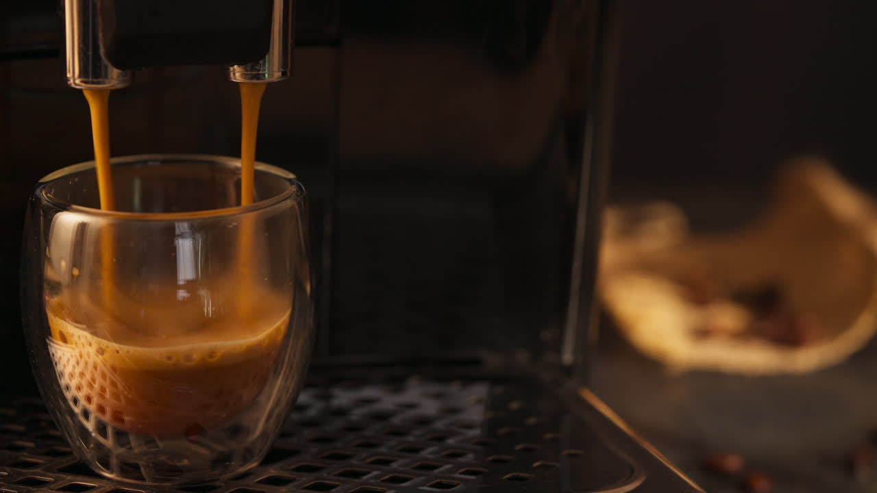 Person holding a cup of coffee fresh from the machine