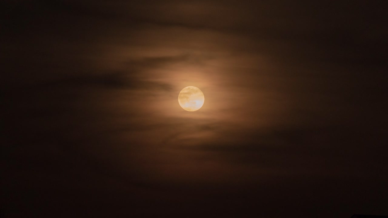 Moon Partially Covered by Clouds at Night