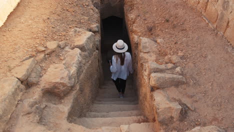 woman exploring an ancient tomb