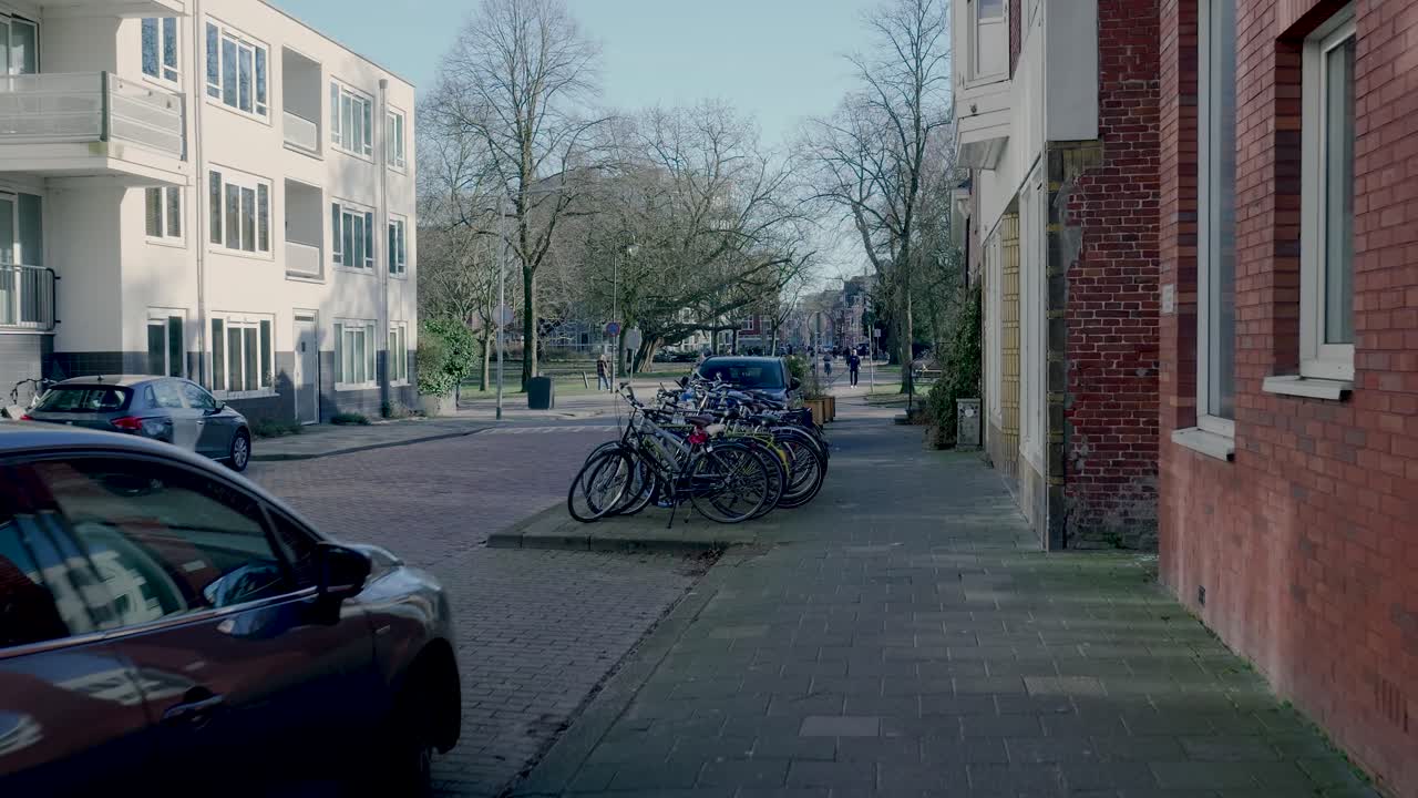 Stille villavej med parkerede biler og cykler