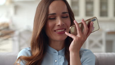 smiling business woman recording vioce message on the phone at home office