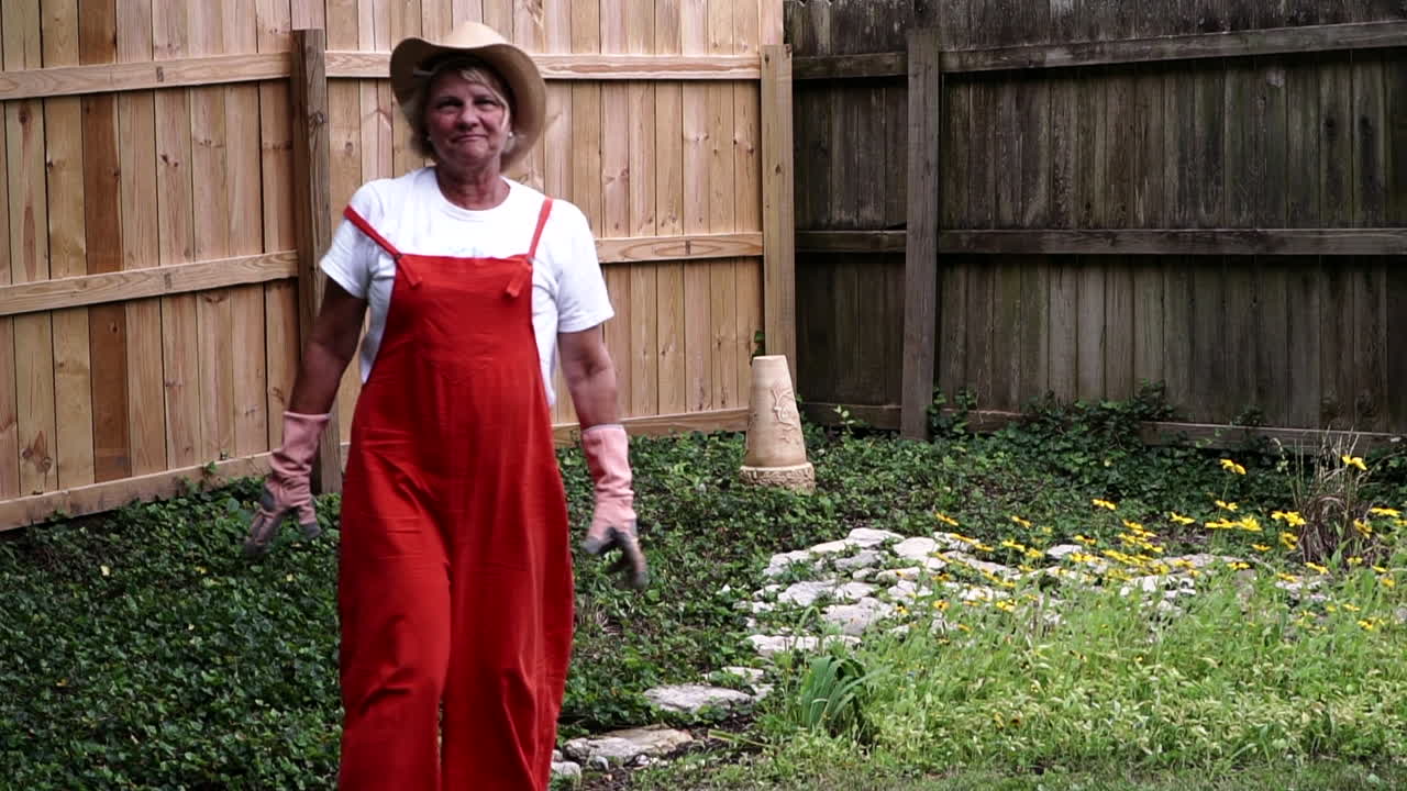 오하이오주 센터빌에서 원예를 마친 후 장갑을 끼고 손을 닦는 여성 정원사 - 미디엄 풀 샷, 슬로우 모션