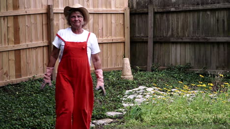 A-Female-Gardener-Dusting-Off-Hands-With-Gloves-After-Gardening-In-Centerville,-Ohio---medium-full-shot,-slow-motion