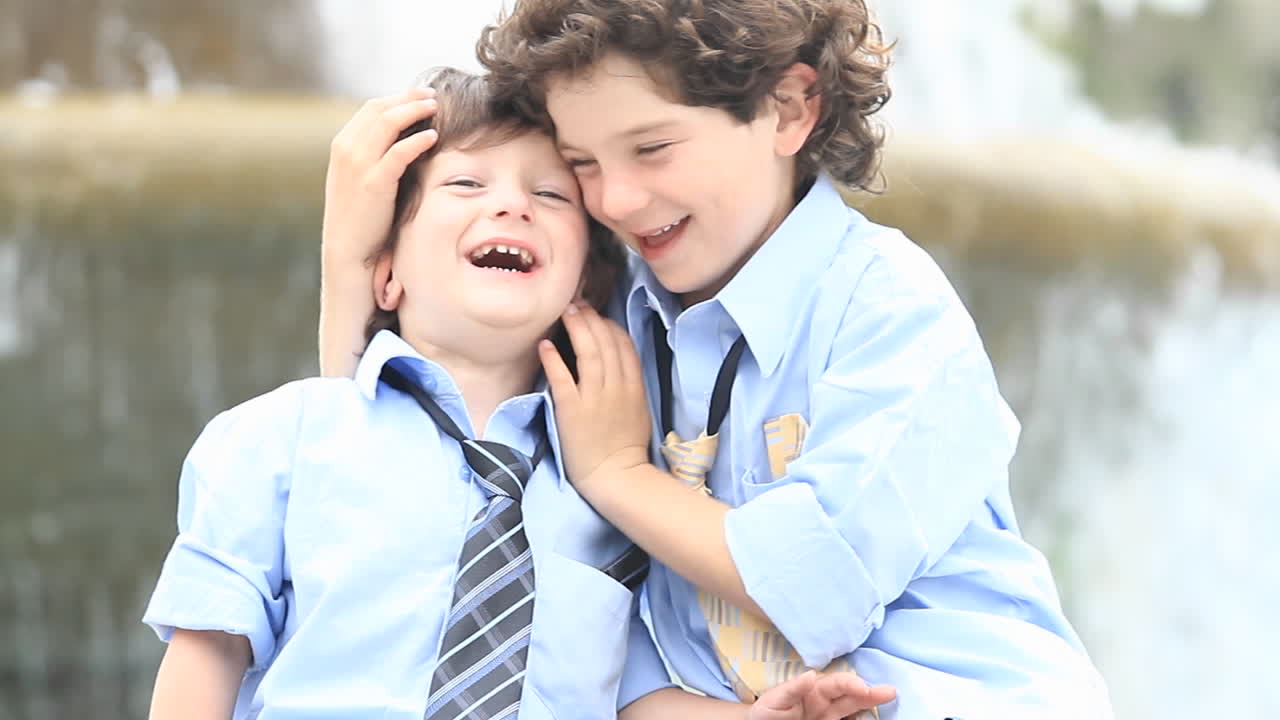 예복을 입은 소년 한 쌍이 분수대 앞에서 놀고 있다 1