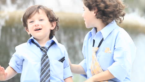 a pair of boys in formal dress play in front of a fountain  1