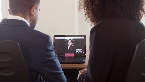 pareja de negocios saludando a un colega en la pantalla de la computadora portátil