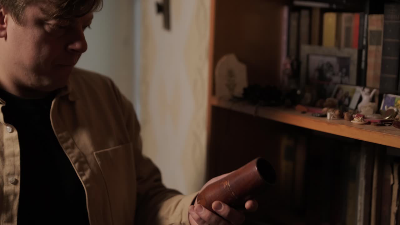A man collects old things in a box to move from his old house. He leaves his old apartment and is sad