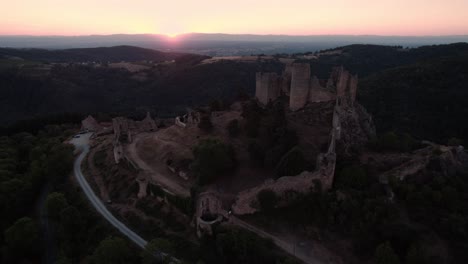 aérea alrededor del castillo de couzan al amanecer, fortaleza medieval francesa en el departamento del loira, loira forez, campo francés