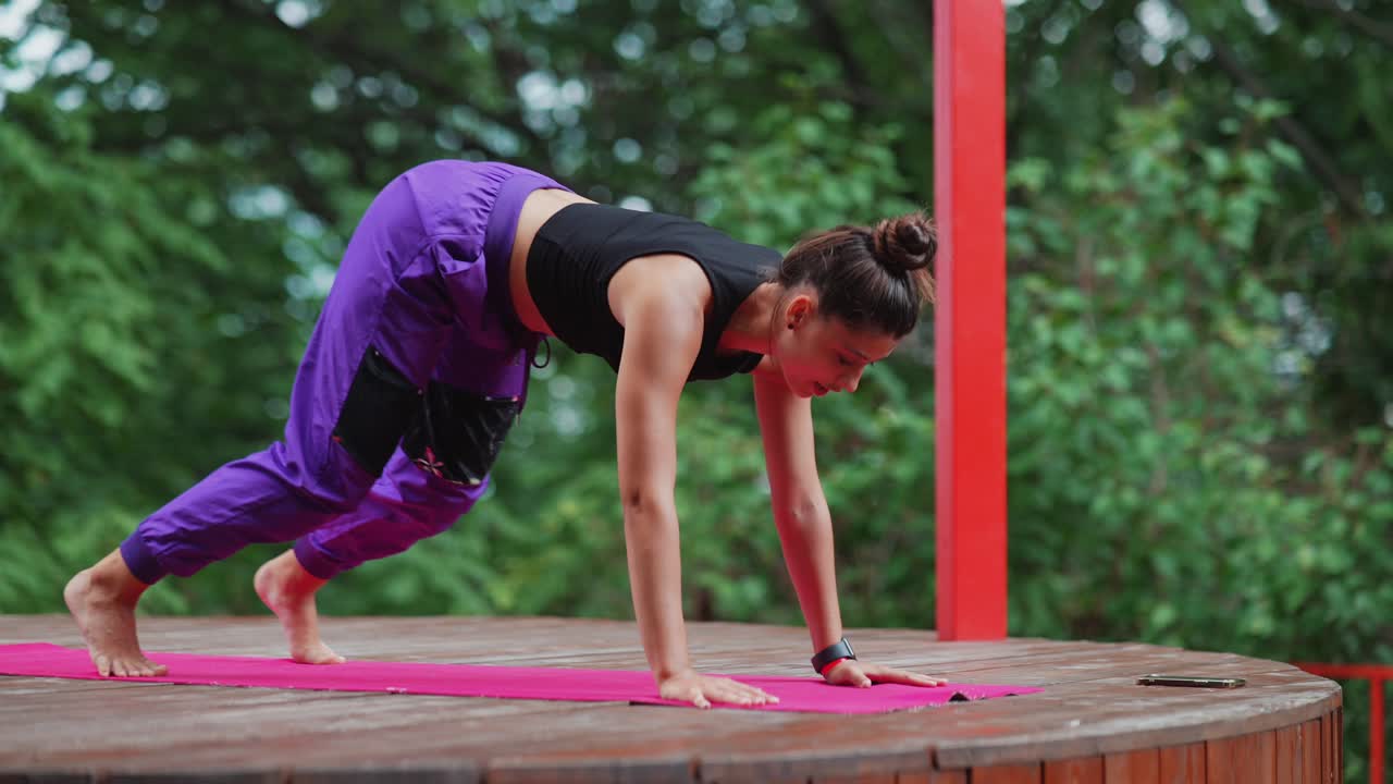 mujer practicando yoga para perros mirando hacia abajo al aire libre