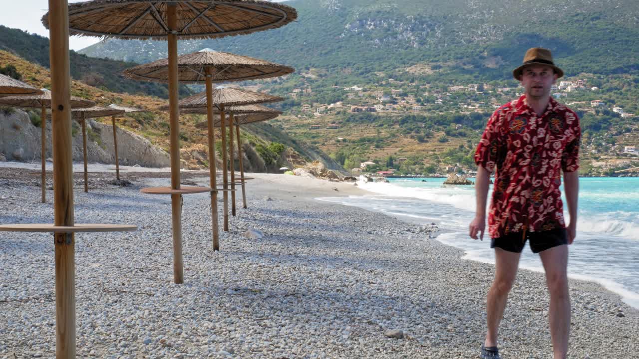 A Male Tourist Walking On Pebbled Shore In A Beautiful Agia Kiriaki Beach, Zola In Kefalonia, Greece