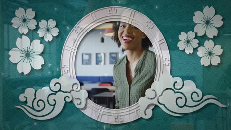 framed by floral and cloud patterns, woman in green sweater smiling