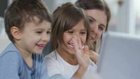 mother and her two sons wave hands on a video call