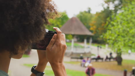 Nahaufnahme-Einer-Frau-Im-Freien-Mit-Einer-DSLR-Kamera,-Die-Im-Sommer-Im-Stadtpark-Fotos-Macht