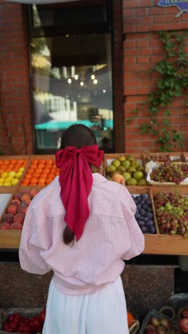 woman shopping for fresh fruit at a market