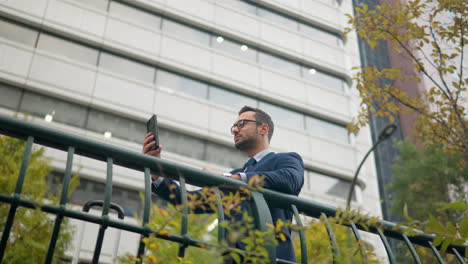 El-Empresario-Utiliza-El-Teléfono-Al-Aire-Libre.