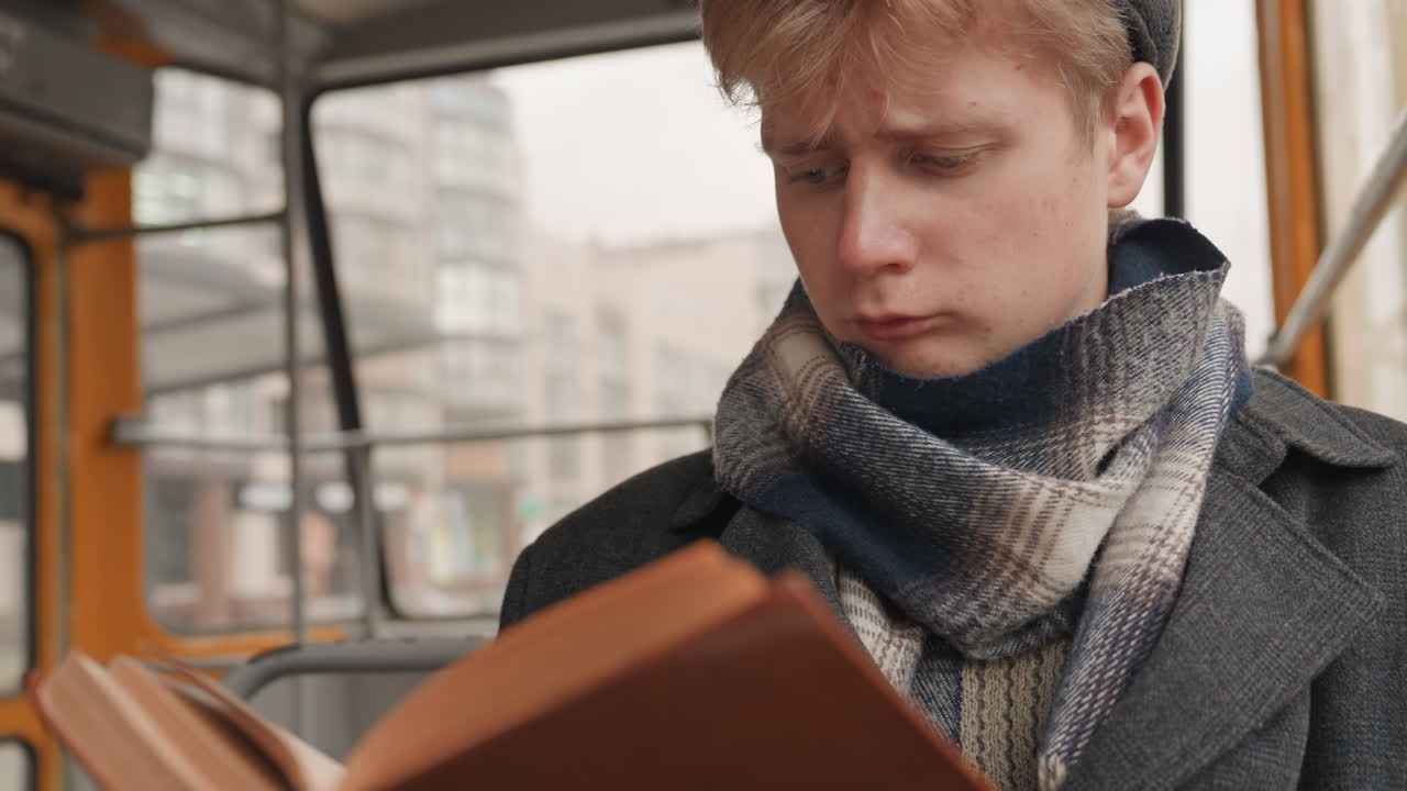 Un ragazzo si diletta in una storia coinvolgente. Un giovane sorridente è assorto in un'esperienza narrativa cittadina accattivante. Un giovane uomo soddisfatto si diverte a esplorare e vivere avvincenti avventure narrative urbane.
