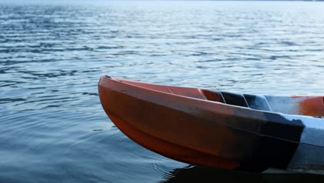 un kayak flota y se mueve lentamente en un lago tranquilo.