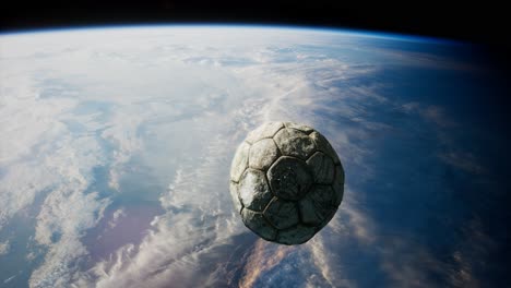 old soccer ball in space on earth orbit