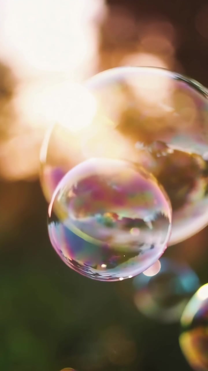Bolle di sapone iridescenti che fluttuano alla luce dorata del sole