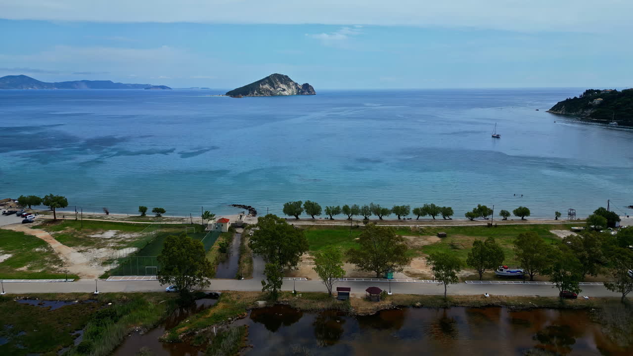 Aerial horizon background, establishing of Mediterranean blue sea beach shore landscape with trees, island in the middle of the water