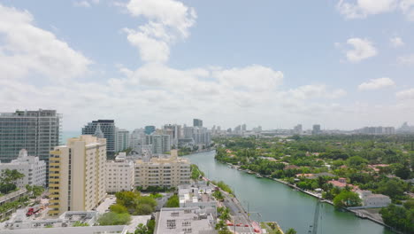 Luxury-residences-and-apartment-buildings-along-river.-Forwards-fly-above-urban-borough-in-tropical-destination.-Miami,-USA