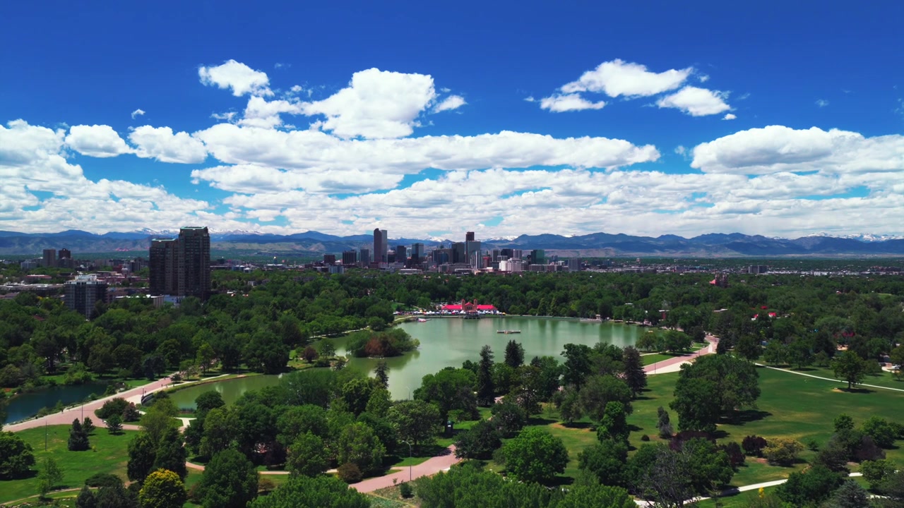 City Park, Lago Ferril, Denver. Padiglione del City Park, grattacieli, skyline di Denver, Colorado. Drone aereo. Mattina di primavera, cielo blu. Sentiero pedonale del quartiere, paesaggio urbano. Movimento in avanti e verso l'alto.