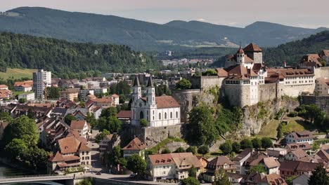 aerial - twin tower church and aarburg castle stand on rocky cliff in solothurn switzerland