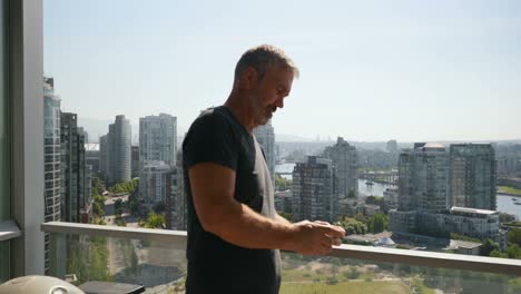 hombre usando teléfono móvil en balcón 4k