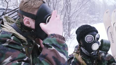 soldiers in camouflage with gas masks in snowy terrain