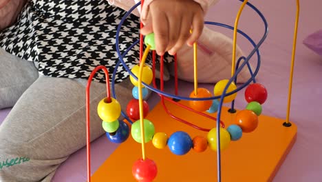 child playing with a colorful ball maze toy